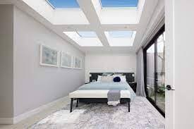 four fixed skylights installed above all white modern bedroom