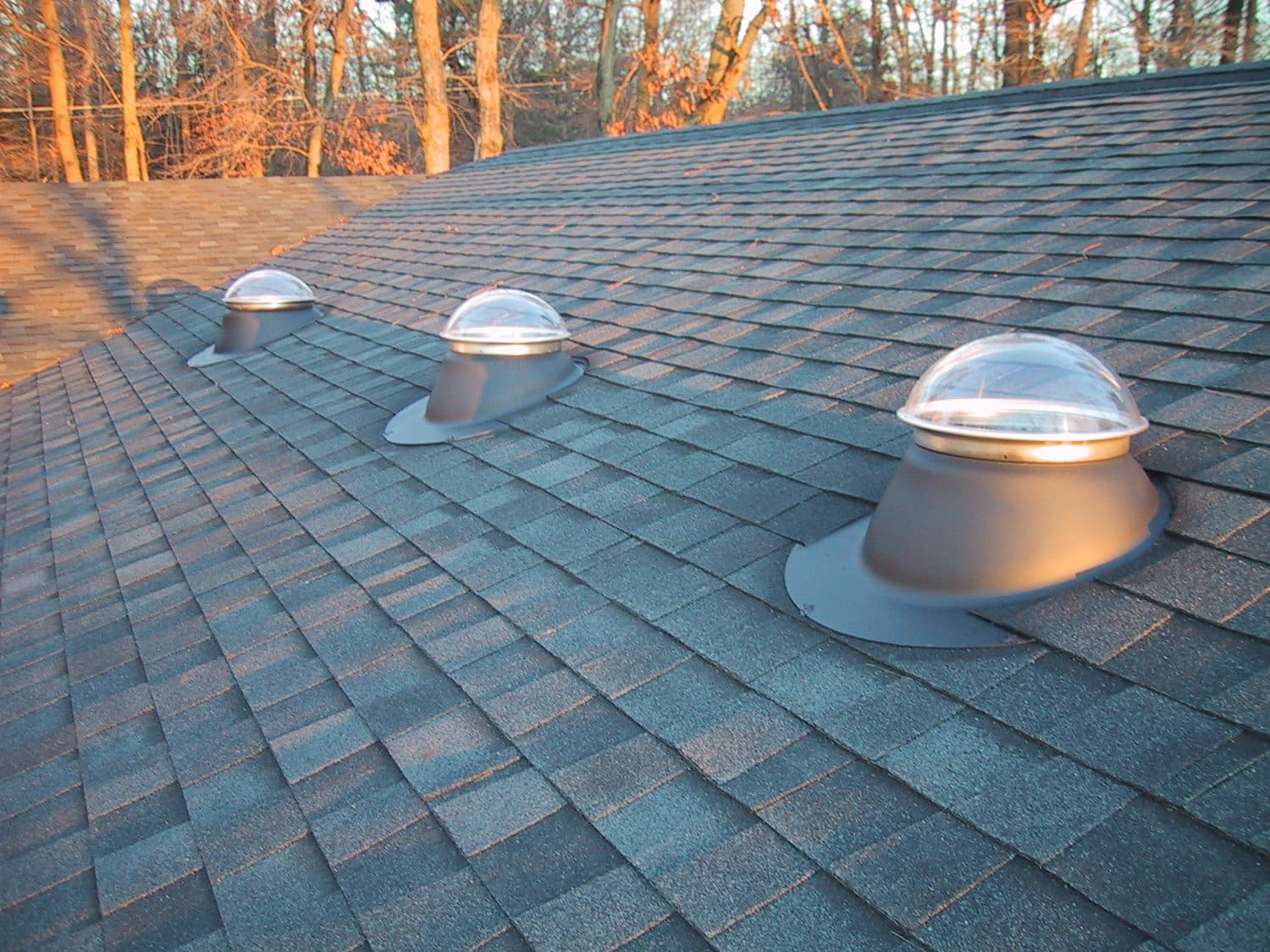 Tubular skylights on dark shingle roof